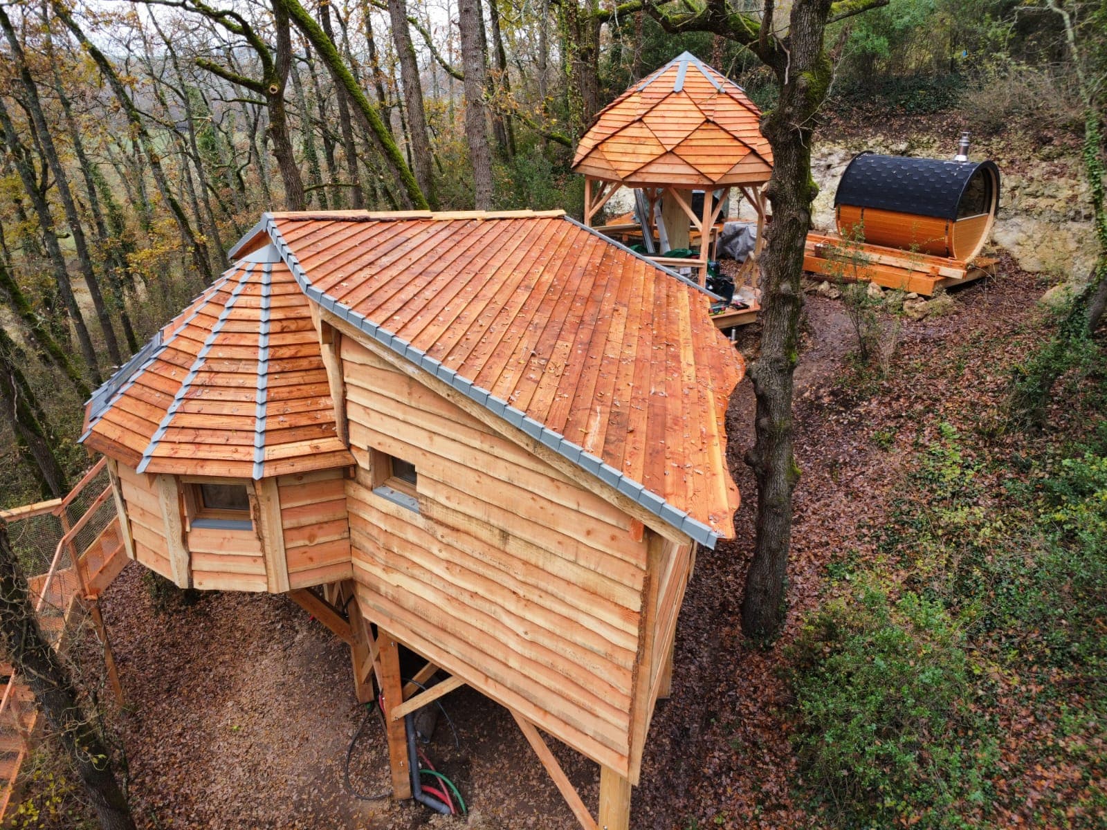 Cabane en ossature bois et toiture en tuiles dans un sous-bois