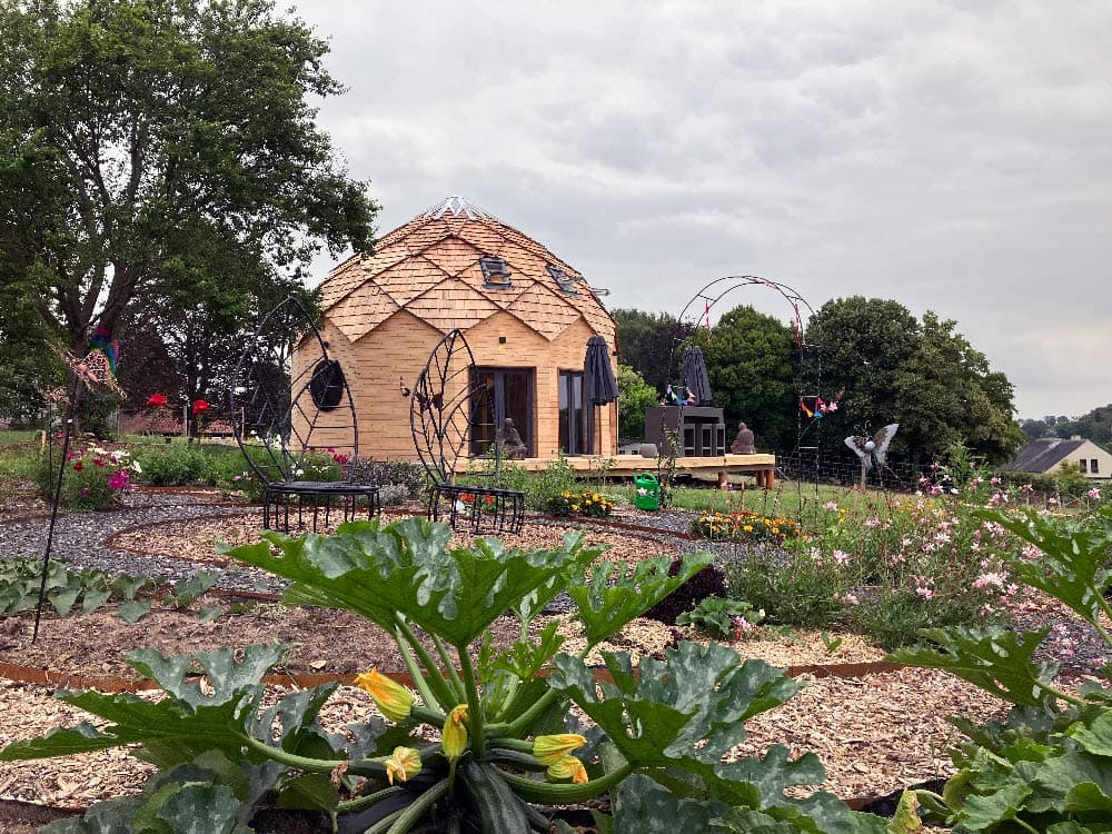 Zome en bois installé dans un jardin potager