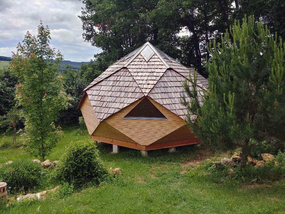 Zome en bois entouré de végétation